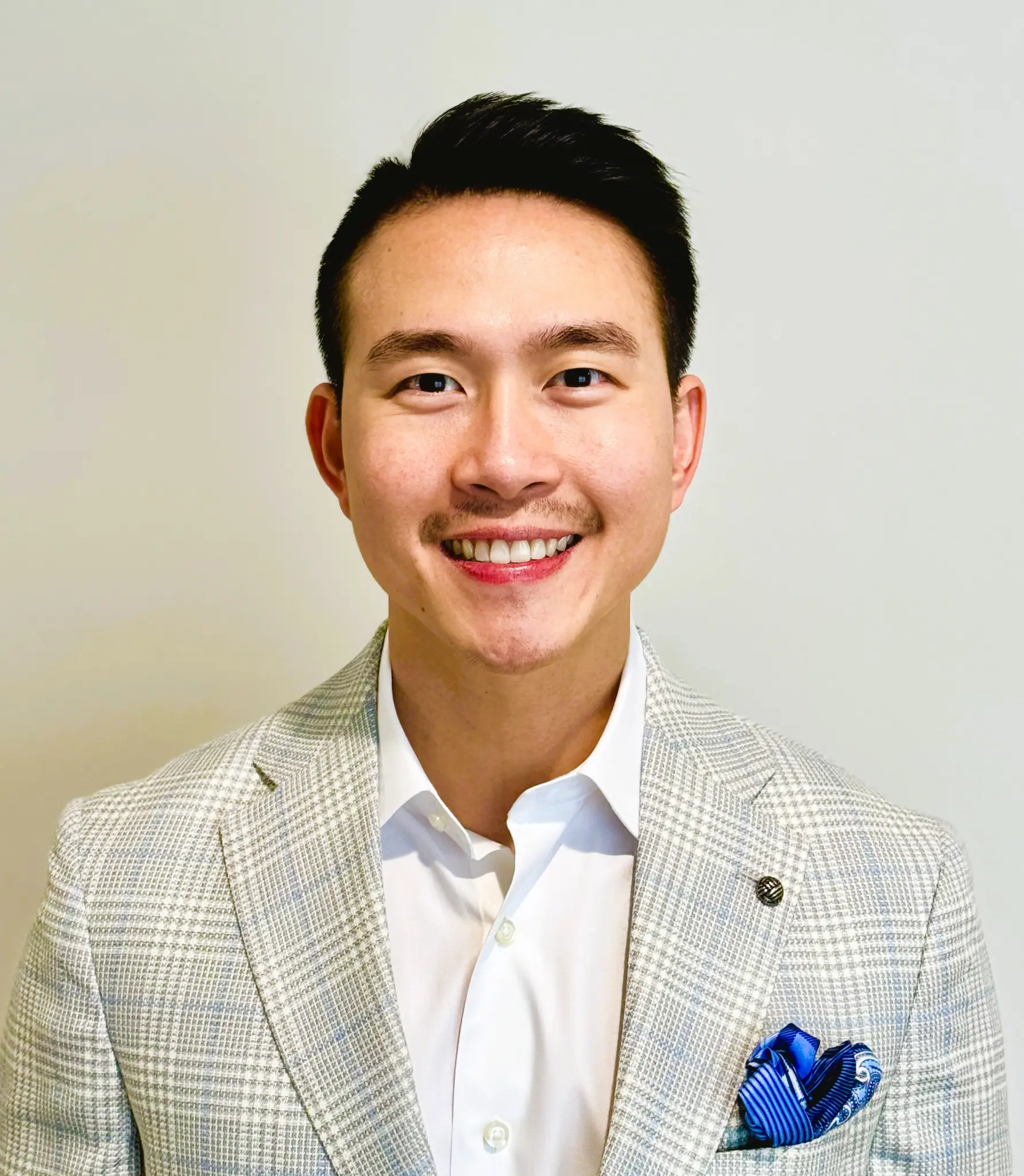 Dr. Hoang Ton smiling in a light gray blazer